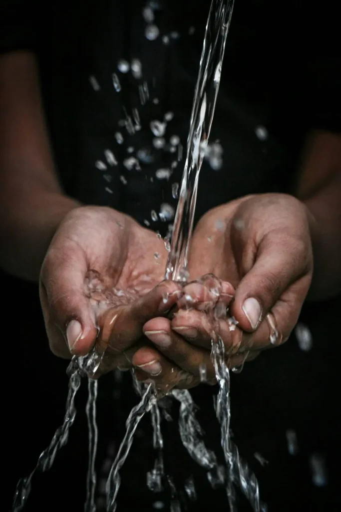 Agua limpia cayendo en las manos