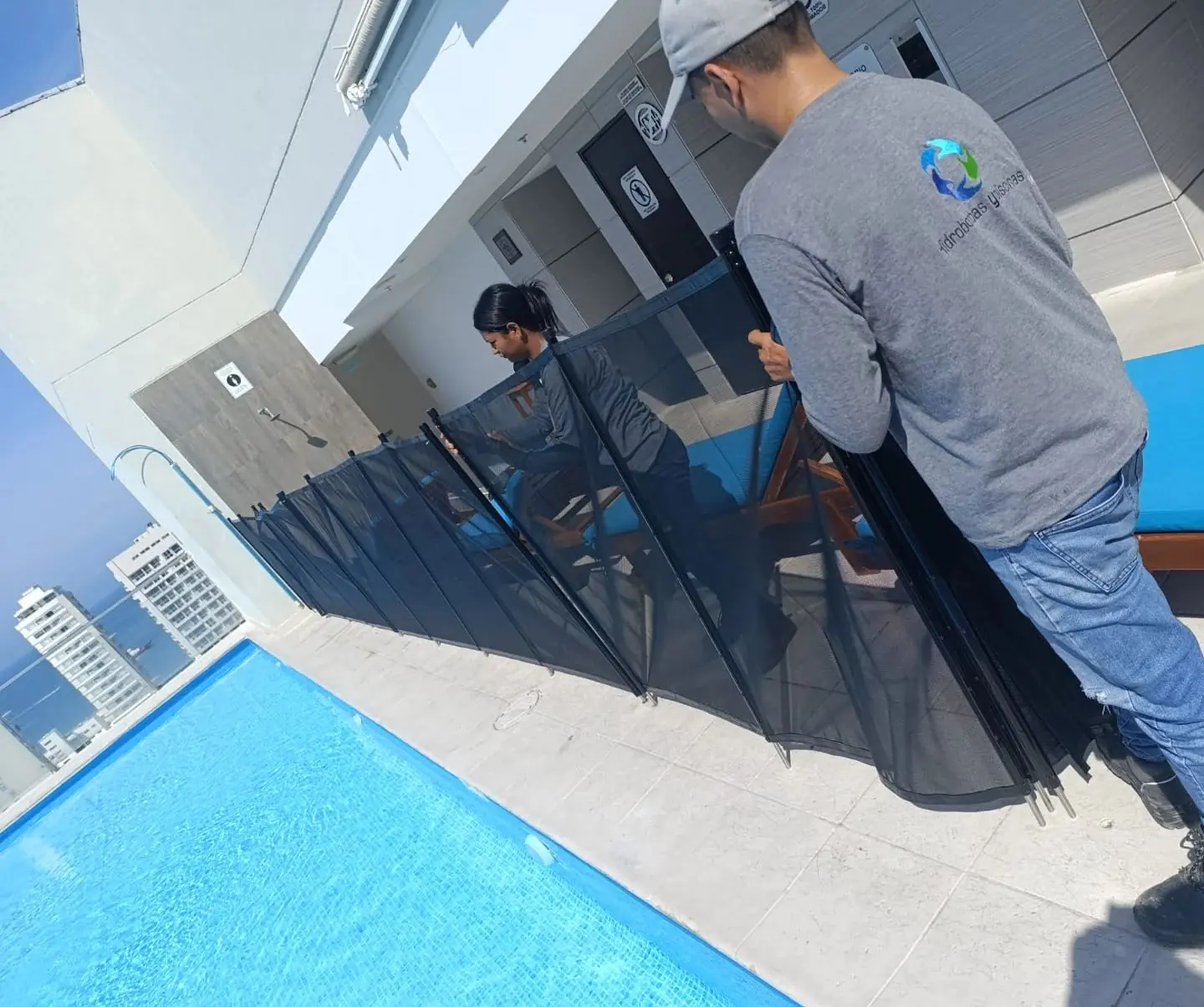 Técnicos de Hidrobombas y Piscinas instalando el cerramiento de seguridad en la azotea de un edificio